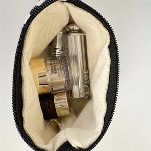 Interior detail of a striped canvas coin purse showing large capacity for cosmetics