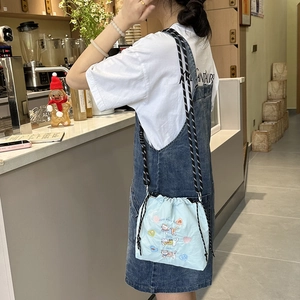Close-up of light blue nylon crossbody bag with cat embroidery and rope strap