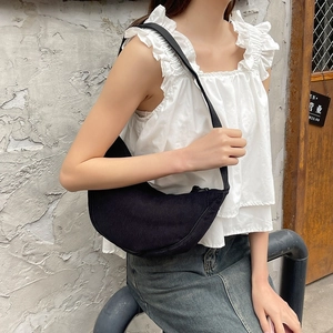 Detail of black corduroy crescent crossbody bag with minimalist wide shoulder strap