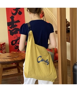 Detail of yellow nylon crossbody bag featuring blue Candy print and durable strap