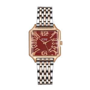 Detail of square watch with deep red dial and rose gold metal linked strap