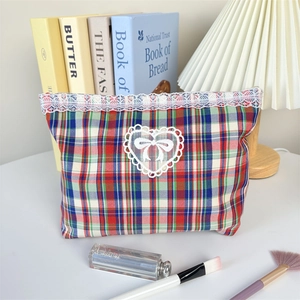 Detail of red and blue checkered makeup bag with white lace trim and heart bow decoration