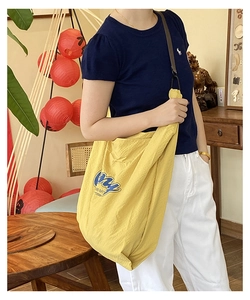 Detail of yellow nylon shoulder bag featuring My GOOD DAY letter print and adjustable strap