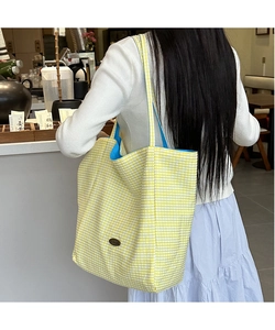 Detail of yellow checkered tote bag with bright blue lining and large capacity storage