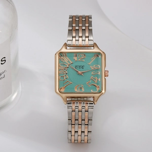 Detailed macro shot of square turquoise dial and bicolor metal strap of the luxury watch