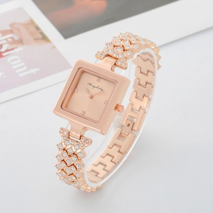 Macro detail of square rose gold quartz watch featuring a crystal encrusted luxury bracelet