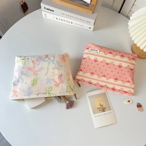Detail of canvas makeup bags with bow prints, floral patterns and metal zipper closure