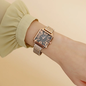 Elegant square quartz watch with rose gold case and bicolor metal strap on woman wrist