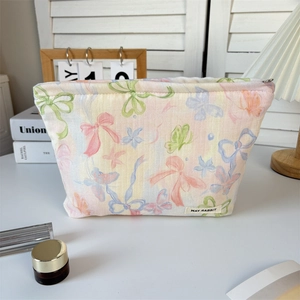 Detail of floral canvas makeup bag with cute bow prints and brand woven label