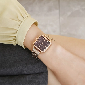 Detail view of a luxury square quartz watch with rose gold strap and diamond dial on wrist