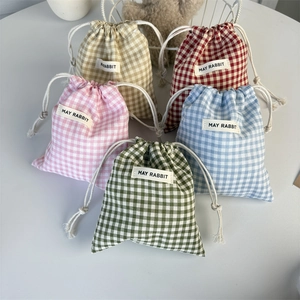 Detailed close-up of colorful checkered cotton linen drawstring pouches for storage