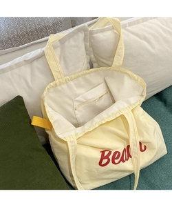 Detail view of the nylon tote bag interior with zipper pocket and Beach print