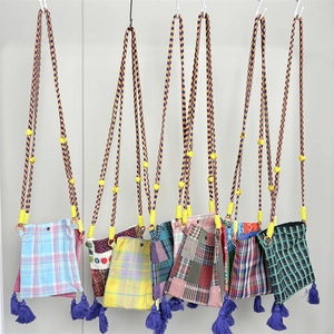 Detail of vintage plaid mini crossbody phone bags with woven straps and purple tassels
