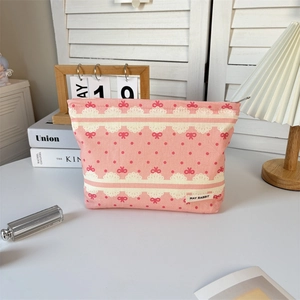 Detail of pink floral bow makeup bag with lace patterns and a durable metal zipper