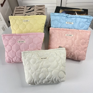 Close-up of quilted floral cosmetic bags showing colorful fabrics and May Rabbit label