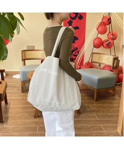 Detailed view of grey canvas tote bag featuring Low Classic brand logo and shoulder straps