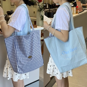 Reversible canvas tote bag with blue checker pattern and Enjoy Your Life slogan