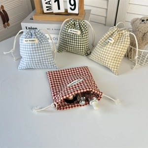 Detail of plaid cotton linen drawstring pouches in various colors with fabric labels