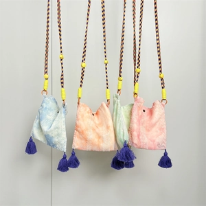 Detail of four colorful tie-dye mini crossbody bags with ethnic embroidery and silk tassels