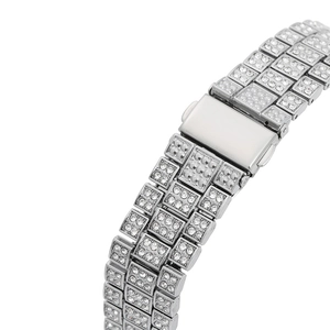 Close-up of luxury silver watch band featuring triple-link design with pavé set crystals