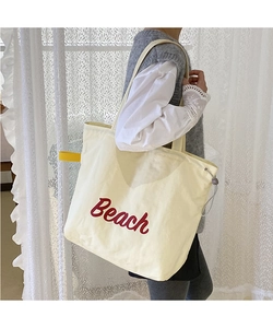 Close-up of Beach print on nylon tote bag with drawstring buckle and yellow handle strap
