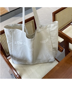 Detailed view of Low Classic letter print on high-capacity cream canvas tote bag