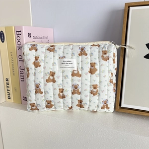 Détail de la texture matelassée et motif ours sur la trousse de toilette zippée