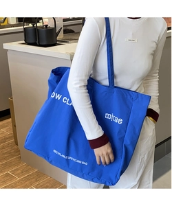 Detail of the Klein blue canvas tote bag featuring white recyclable upcycling lettering