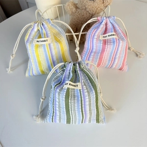 Trois sacs de rangement à rayures avec cordons et étiquette May Rabbit en scène