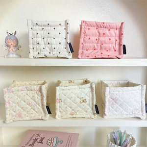Detail showing five quilted fabric storage bins with floral and heart patterns