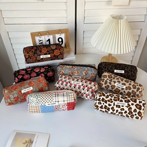 Detail of multiple vintage corduroy pencil cases with various floral and animal prints