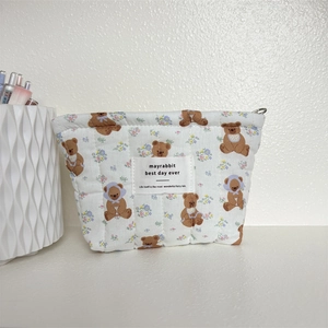 Pochette en coton matelassé avec imprimé ours et étiquette de marque sur fond blanc