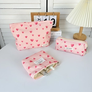 Three-piece pink heart-patterned toiletry bag set with smooth zipper details