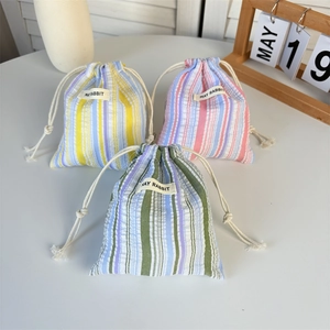 Gros plan de pochettes plissées à rayures en tissu bleu, rose et vert