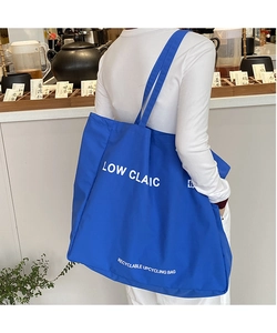 Detail of royal blue canvas tote bag with white lettering for daily casual shopping