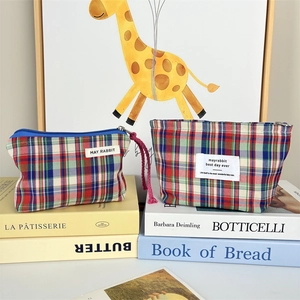 Detail view of two canvas plaid cosmetic bags in classic red and blue British style