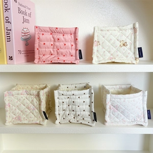 Detailed view of quilted fabric organizers with cute bear and heart prints on white shelves