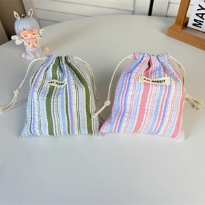 Détail de pochettes à rayures avec cordon et étiquette May Rabbit en coton doux