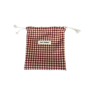 Red and white gingham drawstring storage bag with May Rabbit label on a white background
