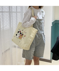 Detail of canvas tote bag featuring cute cartoon panda towel embroidery and side drawstring