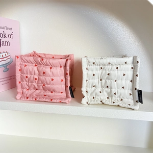 Detailed view of heart-patterned quilted fabric storage bins with brand labels