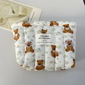 Détail de la trousse en coton matelassé avec ours de dessin animé et fleurs