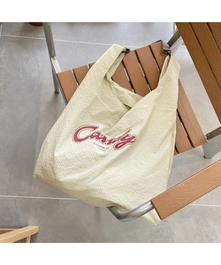 Close-up of waffle fabric tote bag with red Candy print and metal hook details