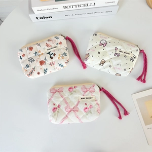 Dettaglio delle borse trapuntate a fiori con cordini intrecciati e mini etichette brand