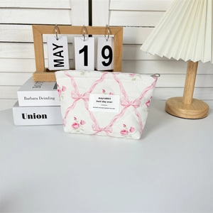 Detailed view of quilted floral cotton makeup bag with rose pattern and zipper closure
