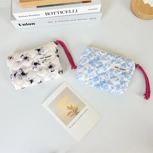 Portamonete trapuntato a fiori con coulisse ed etichetta May Rabbit in un contesto minimal