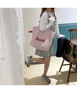 Detail view of pink nylon Beach tote bag being worn by a model in a casual setting