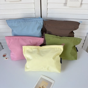 Top view of five colorful nylon grid storage bags with zipper pulls in soft light