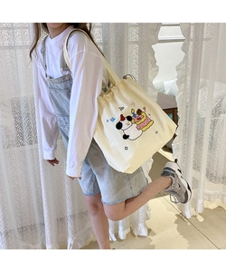 Detail of embroidered cartoon puppy on off-white canvas drawstring shoulder bag