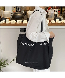 Detail of a large black canvas tote bag with Low Classic logo and recycle slogan print